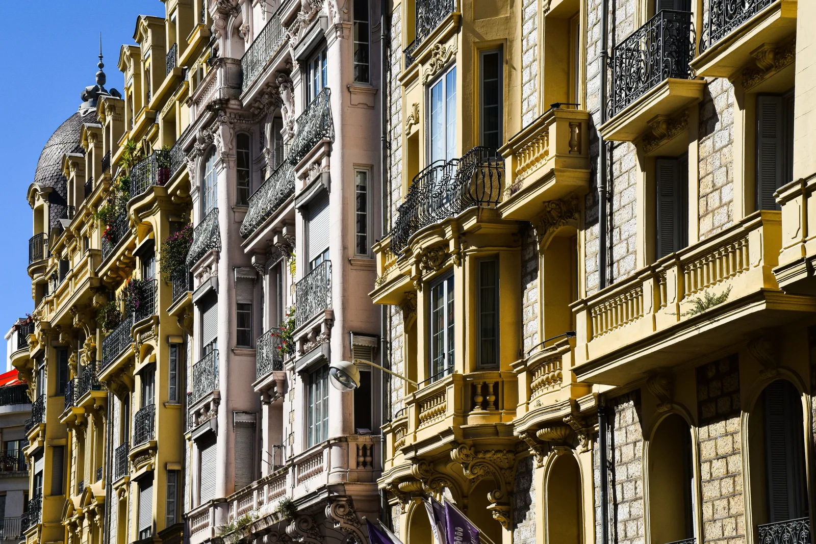 Stone facade with shuttered windows on street in daylight