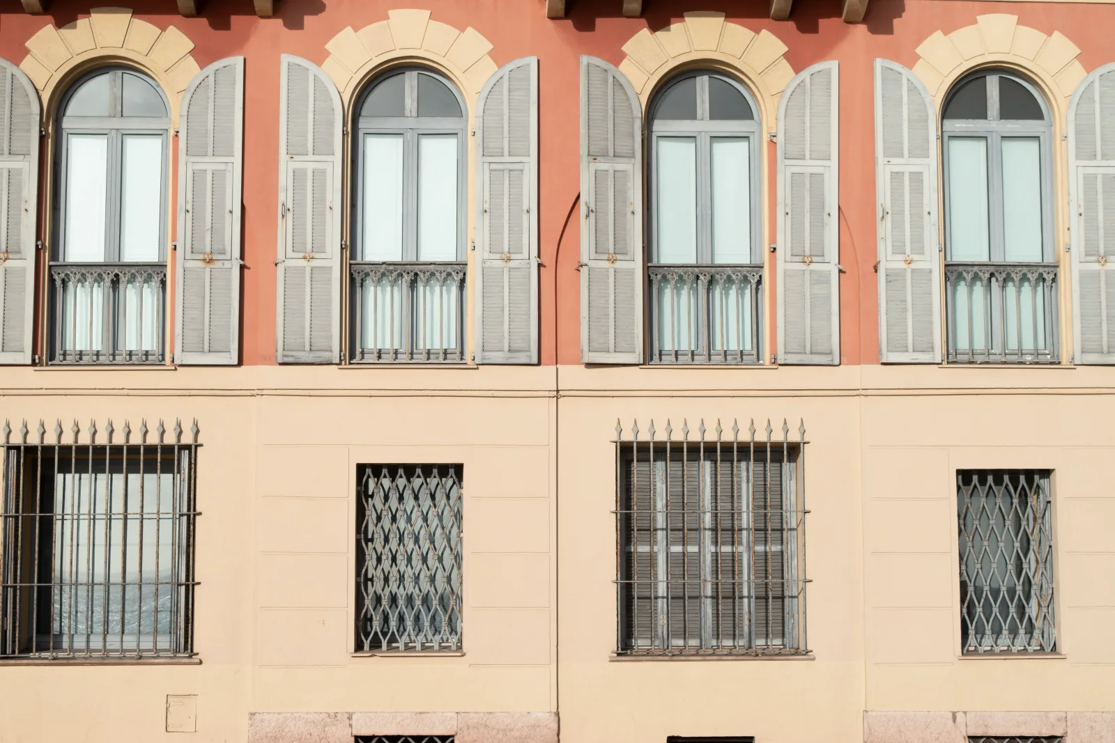 Stone facade of an office building with shuttered windows in daylight