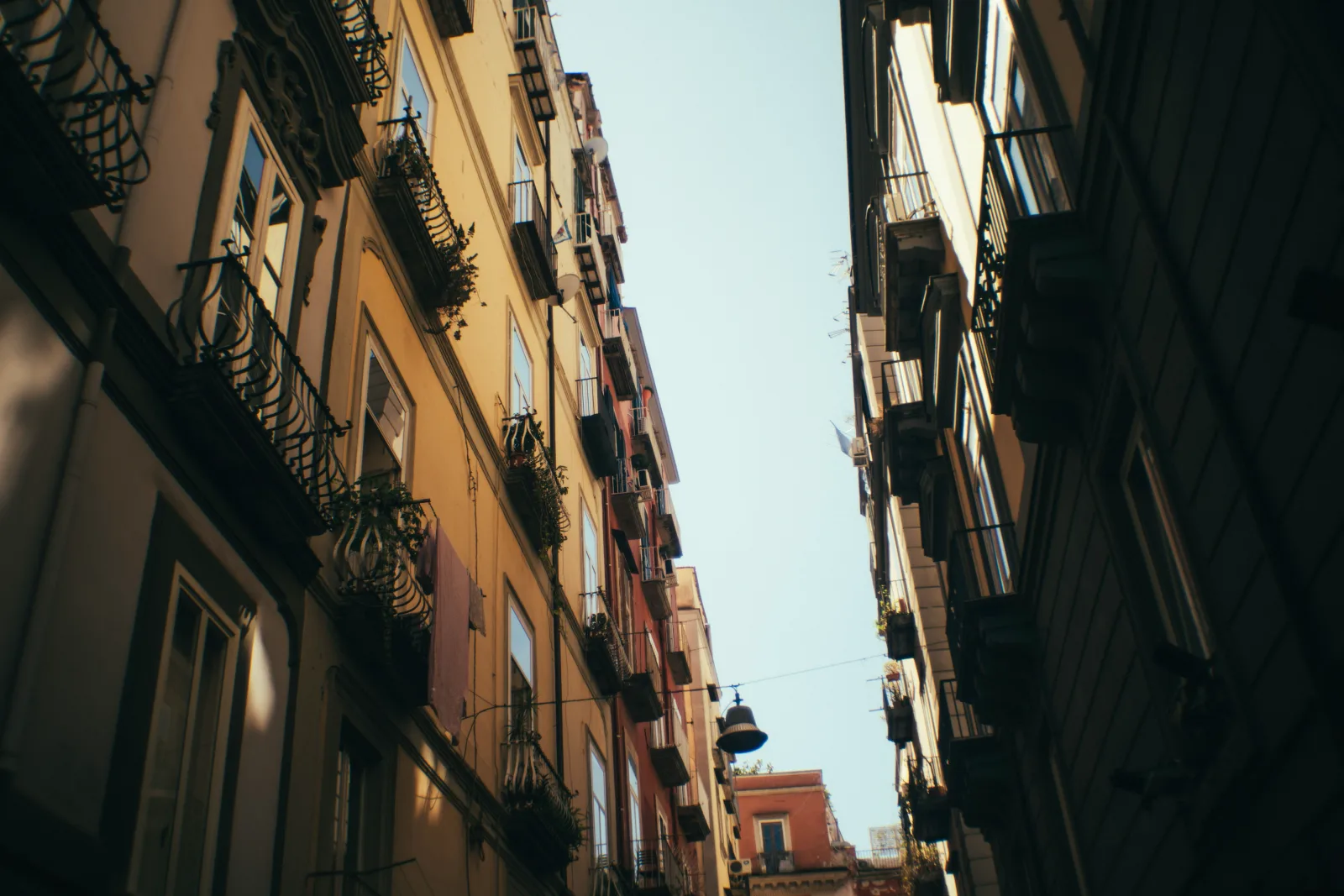 A residential street in morning light, with apartment frontages along the pavement